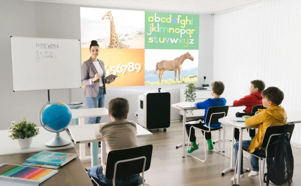 School classroom teacher teaching pupils with projector